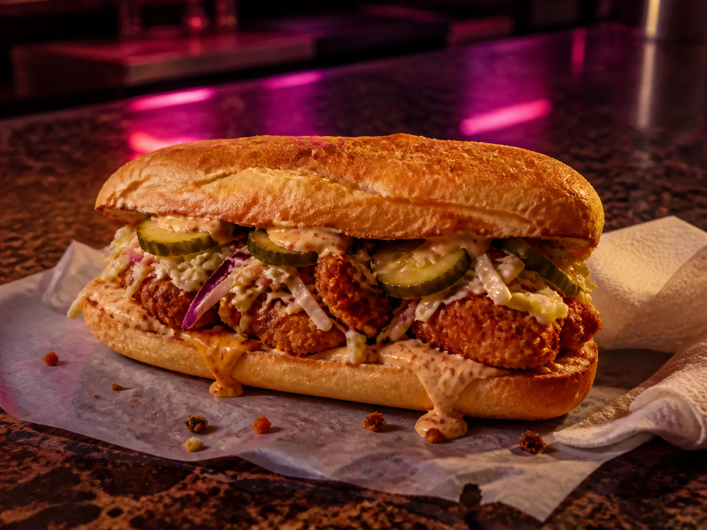 Late-night po'boy special under magenta and amber diner light